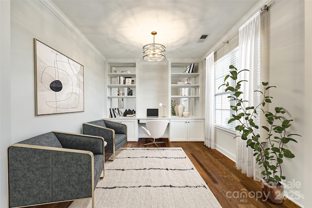 office featuring dark hardwood / wood-style flooring, a notable chandelier, built in shelves, and crown molding