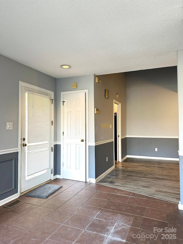 tiled entrance foyer with a textured ceiling