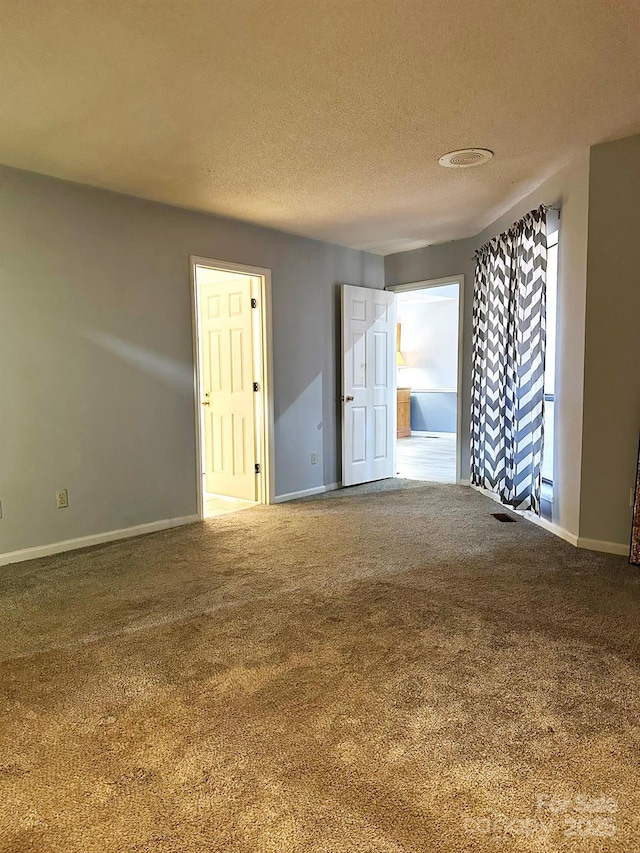 carpeted spare room with a textured ceiling