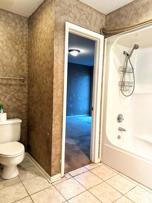 bathroom with toilet, a textured ceiling, shower / washtub combination, and tile patterned floors