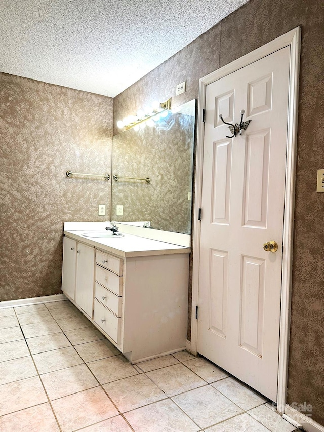 bathroom with a textured ceiling, tile patterned floors, and vanity