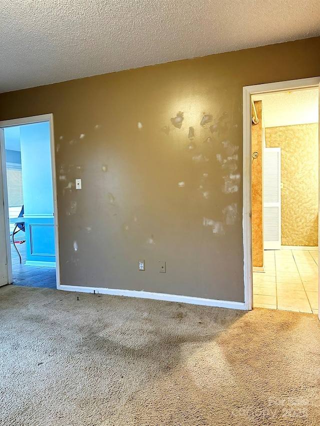 carpeted spare room with a textured ceiling