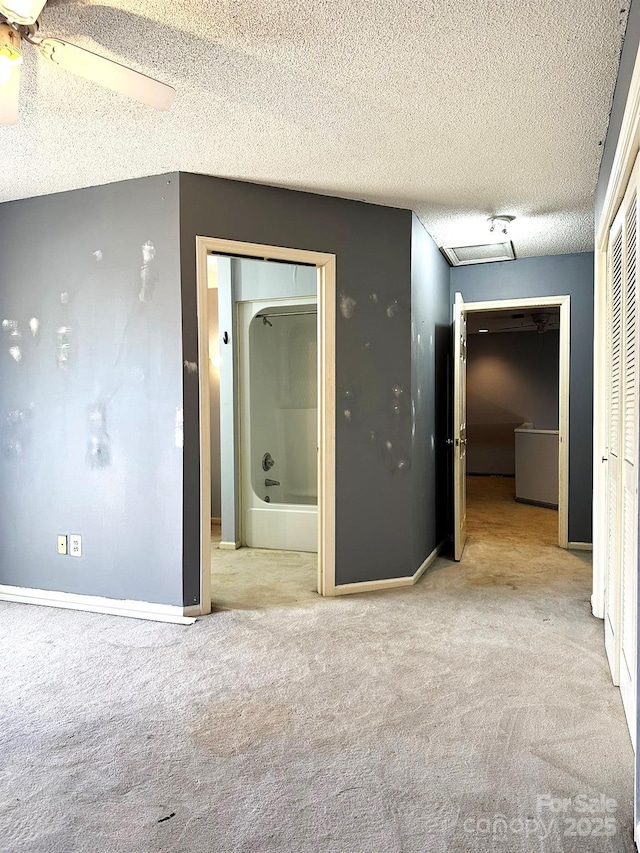 hall featuring a textured ceiling and light carpet