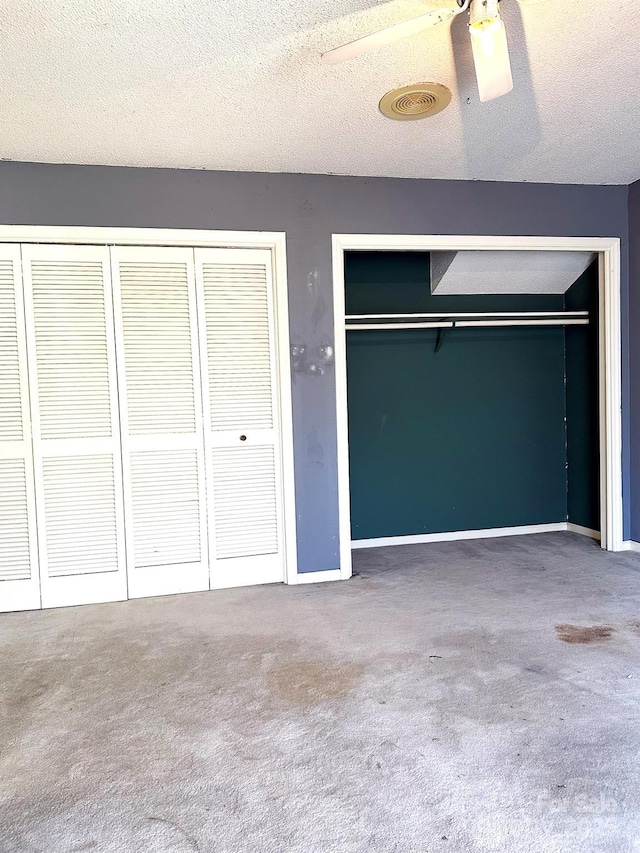 unfurnished bedroom featuring a textured ceiling, ceiling fan, a closet, and carpet