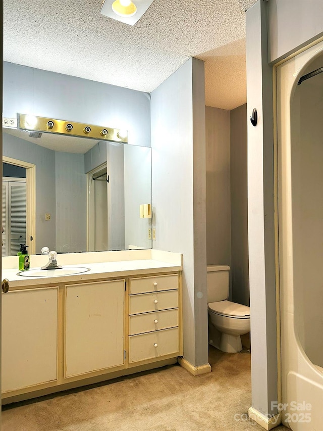 bathroom featuring a textured ceiling, vanity, and toilet