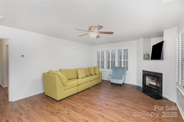 living room featuring wood-type flooring and ceiling fan