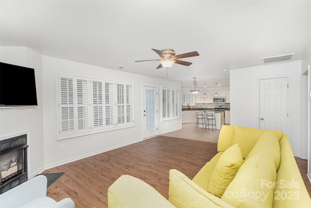 living room featuring hardwood / wood-style flooring and ceiling fan