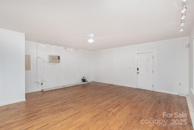 laundry room featuring ceiling fan, a wall mounted air conditioner, track lighting, and light hardwood / wood-style floors