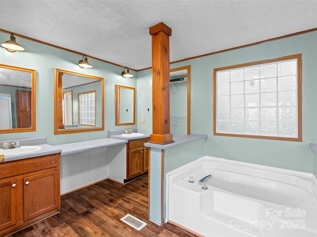 bathroom with vanity, a textured ceiling, and decorative columns