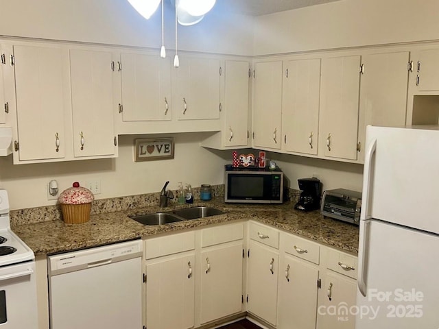 kitchen featuring sink, white appliances, white cabinets, and dark stone counters