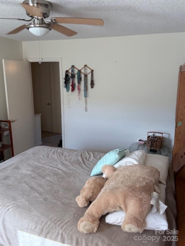 bedroom featuring ceiling fan and a textured ceiling