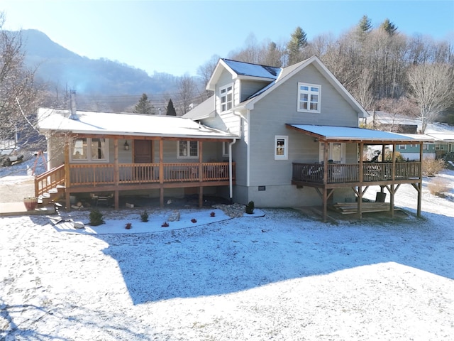 view of snow covered back of property