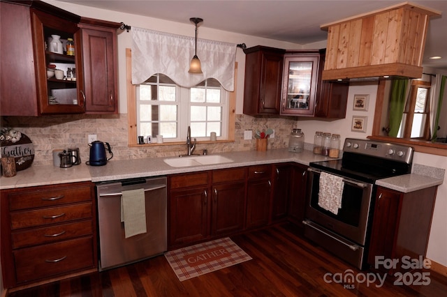 kitchen featuring tasteful backsplash, sink, hanging light fixtures, stainless steel appliances, and dark wood-type flooring