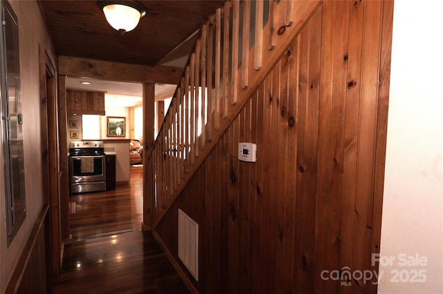 hall with wooden walls, dark hardwood / wood-style floors, and wooden ceiling