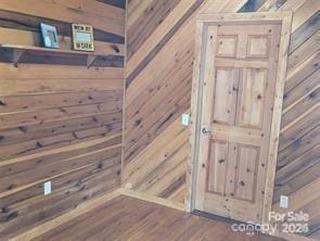 details featuring wood-type flooring and wooden walls