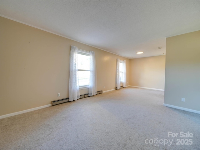 spare room featuring light carpet, baseboard heating, and a textured ceiling