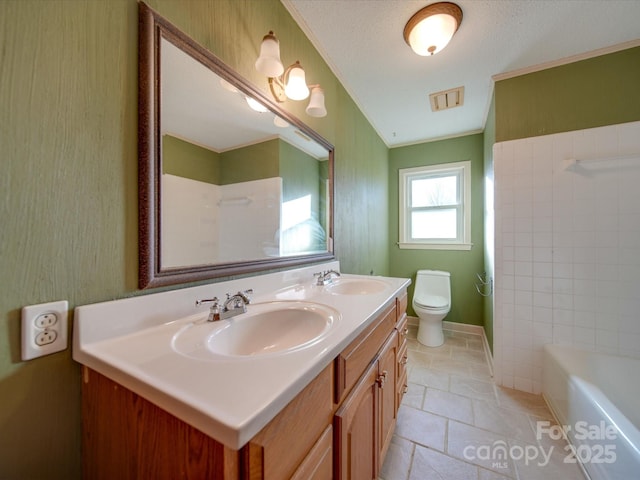 bathroom featuring toilet, a textured ceiling, a tub to relax in, and vanity