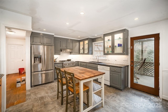 kitchen with gray cabinetry, stainless steel fridge, sink, dishwasher, and decorative backsplash