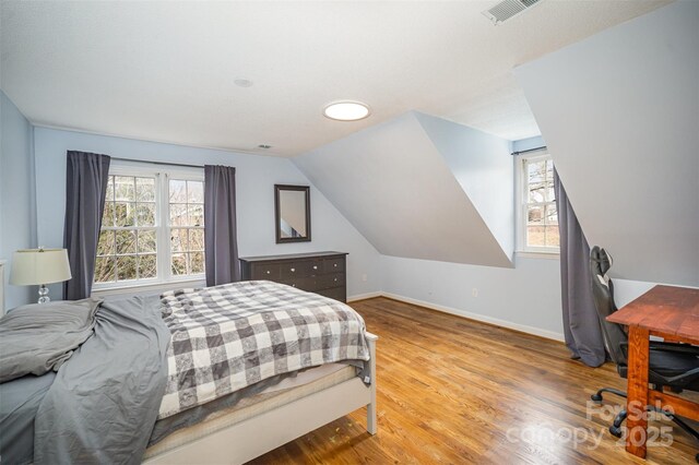 bedroom featuring vaulted ceiling and wood-type flooring