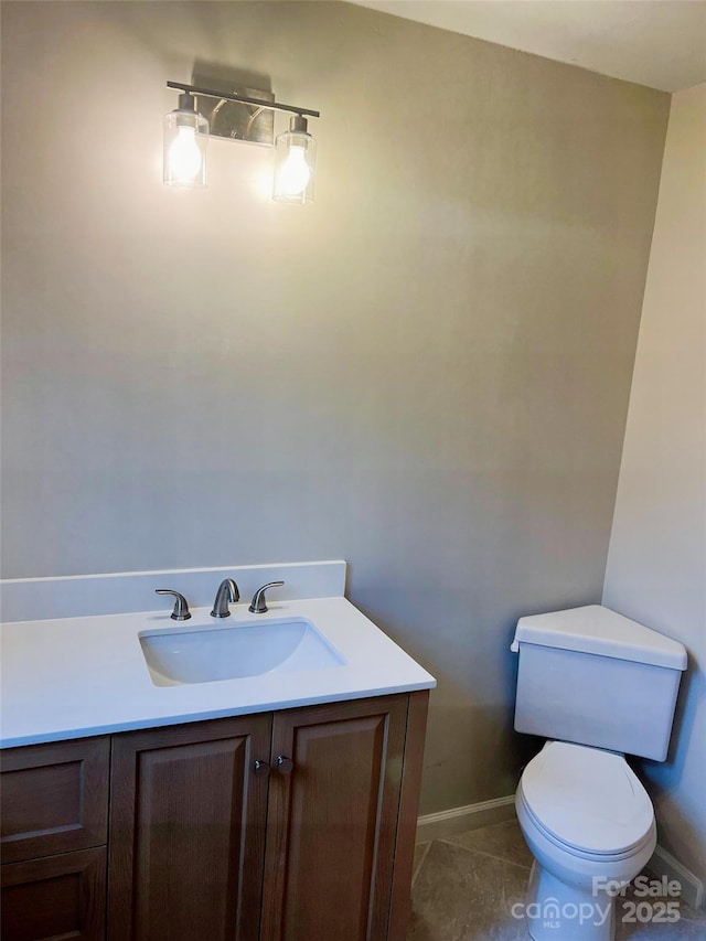 bathroom with toilet, tile patterned floors, and vanity