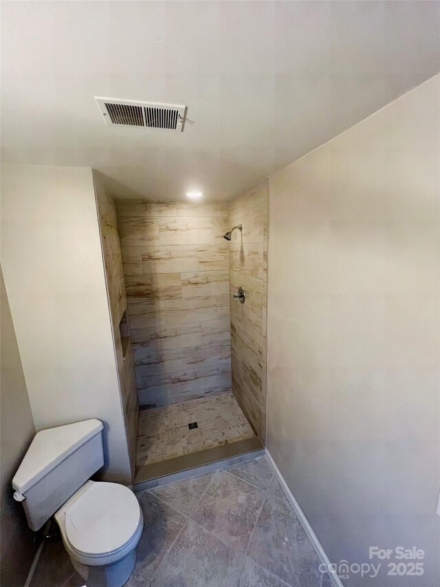 bathroom featuring toilet and tiled shower