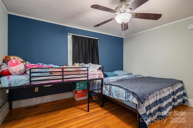 bedroom featuring ceiling fan, wood-type flooring, and crown molding