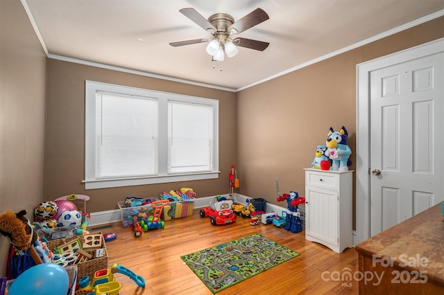 game room featuring crown molding, hardwood / wood-style floors, and ceiling fan