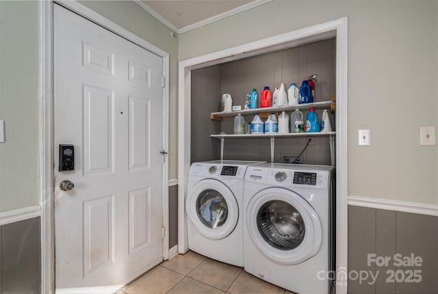 laundry area with washing machine and clothes dryer, crown molding, and light tile patterned floors