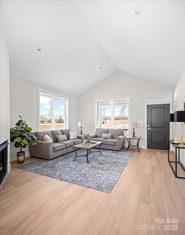 living room with lofted ceiling, ceiling fan, and light hardwood / wood-style floors