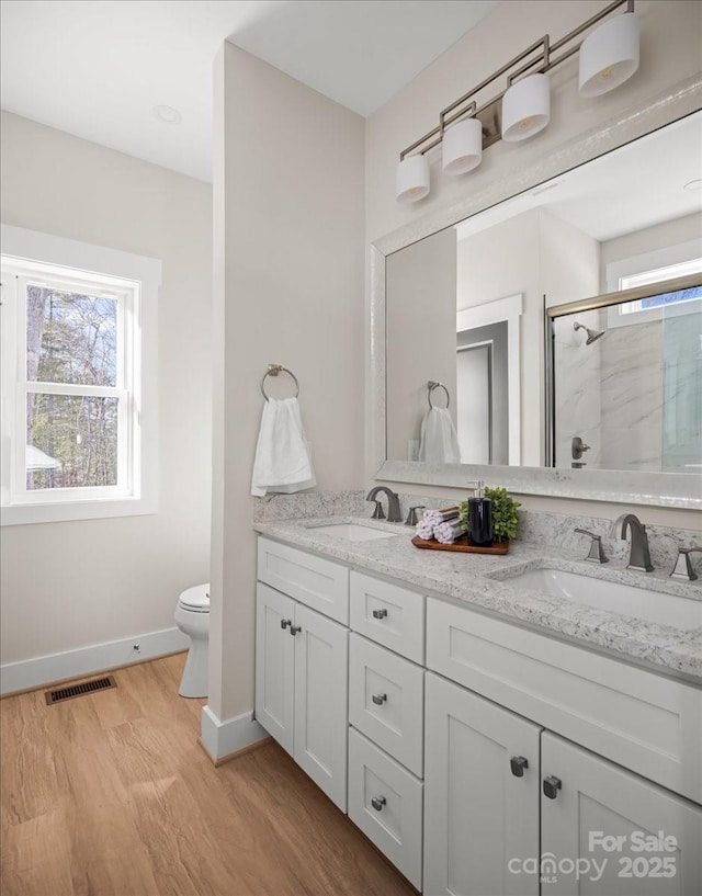 bathroom with a shower with door, toilet, vanity, and hardwood / wood-style flooring