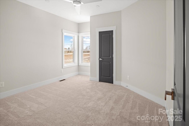 carpeted spare room featuring ceiling fan