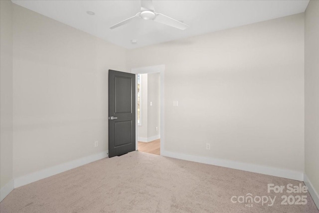 carpeted spare room with ceiling fan