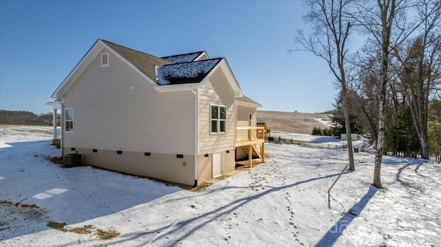 snow covered property with central AC