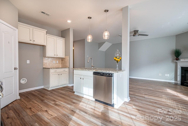 kitchen with white cabinetry, ceiling fan, backsplash, dishwasher, and light stone countertops