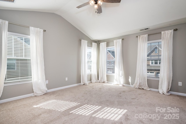 carpeted spare room featuring ceiling fan and vaulted ceiling