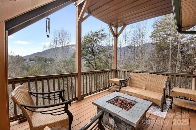 wooden terrace with a mountain view and a fire pit