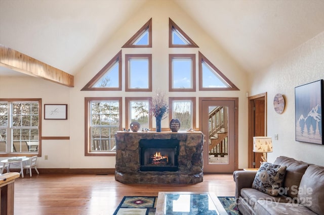 living room with a wealth of natural light, a fireplace, and light hardwood / wood-style floors