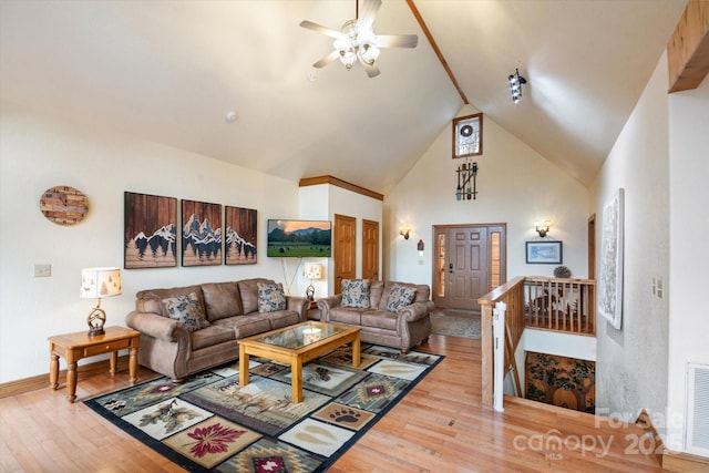 living room featuring hardwood / wood-style flooring, high vaulted ceiling, and ceiling fan
