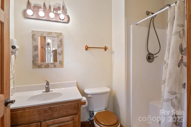 bathroom with vanity, curtained shower, and toilet