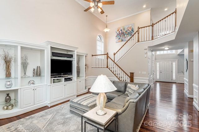 living room with crown molding, dark hardwood / wood-style flooring, and a high ceiling