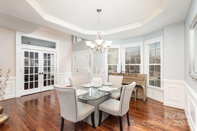 dining room featuring dark wood-type flooring, a raised ceiling, and french doors