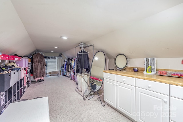 walk in closet featuring lofted ceiling and light carpet