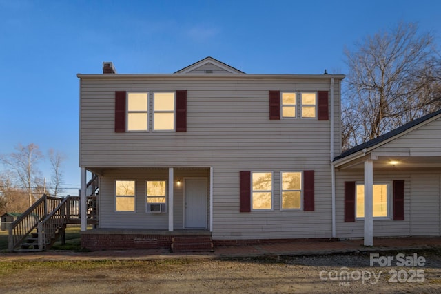 view of front of property featuring cooling unit and a porch