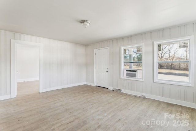 empty room with cooling unit and light hardwood / wood-style flooring