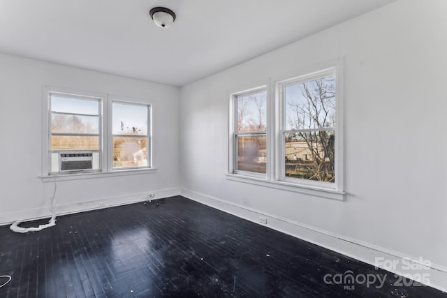 unfurnished room with cooling unit and hardwood / wood-style flooring