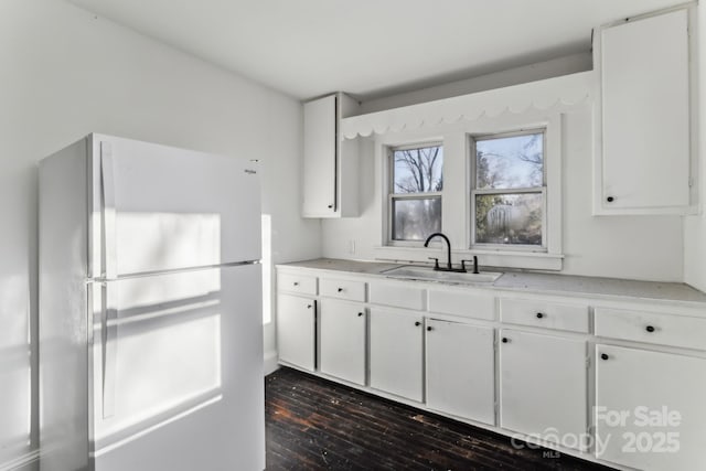 kitchen featuring sink, white cabinetry, dark hardwood / wood-style floors, and white fridge