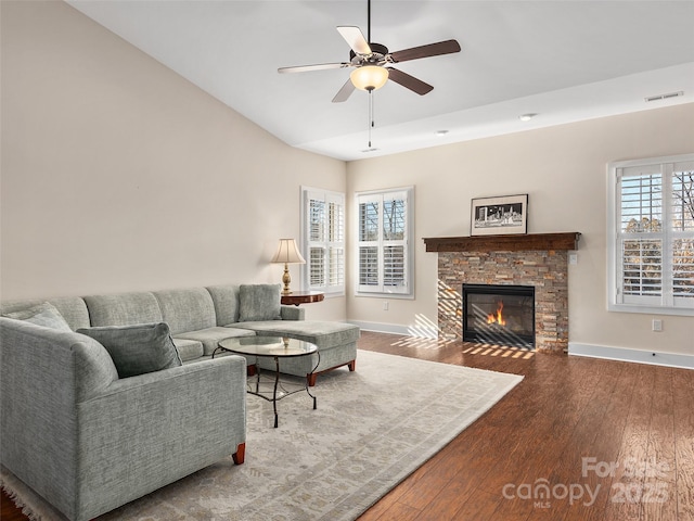 living room featuring ceiling fan, hardwood / wood-style floors, a wealth of natural light, and a fireplace