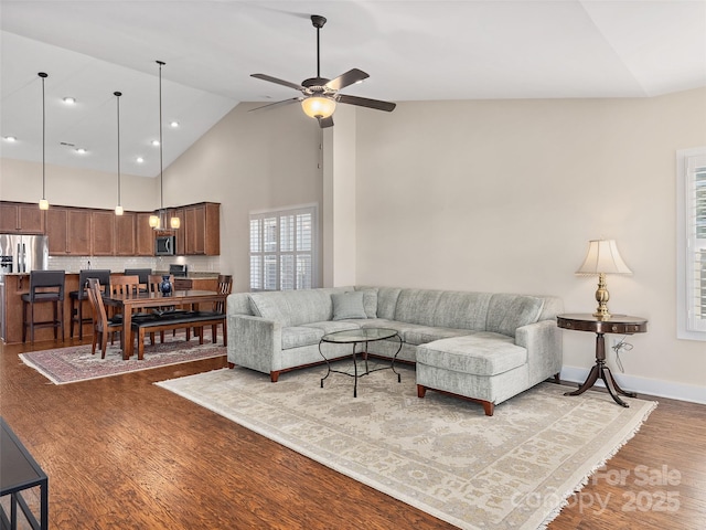 living room with high vaulted ceiling, ceiling fan, and hardwood / wood-style floors