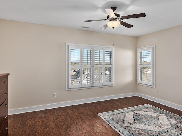 empty room with ceiling fan and dark hardwood / wood-style flooring