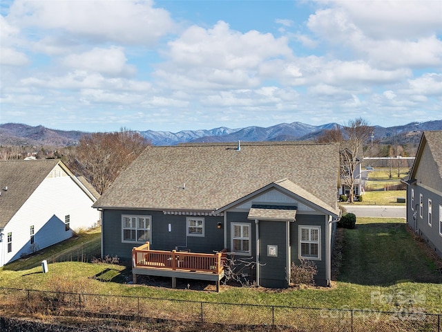 back of property featuring a yard and a deck with mountain view